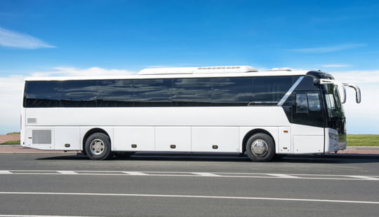 a plain white bus with a DTS logo on the back